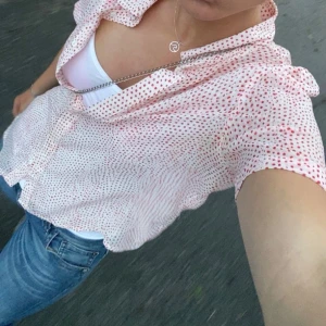 Vit och röd prickig blus - Säljer en söt vit blus med röda prickar. Blusen har korta ärmar och en klassisk krage. 💕
