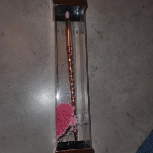 Ögonskuggsborste - Snygg ögonskuggsborste med ett vridet handtag i roséguld.  Flärpen längst upp har lossnat men inget som stör. 
