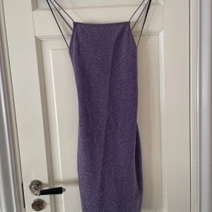 Lila klänning  - Säljer en snygg lila glittrig klänning från H&M.  Den har smala axelband och en elegant, figurnära passform. Köpte för en halloween kostym. Tyckte inte om hur den satt på mig med större byst så använder den inte. Jätteee fin rygg dock! Om du vill ha en bild hur den ser ut på är det bara att fråga😊