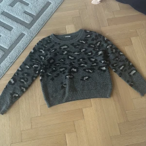 Grå leopardmönstrad tröja från VILA - Säljer en snygg grå tröja från VILA med  jättefina leopardmönster i svart och vitt.💞 Tröjan är stickad och har långa ärmar. Den har en rund halsringning och ribbade kanter.