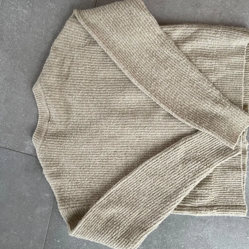 Säljer en mysig beige stickad kofta från LMTD. Koftan har en v-ringad design med knappar framtill och långa ärmar. Perfekt för kyligare dagar och lätt att matcha med olika outfits.. Neuletakit & Villapaidat.