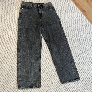 Svarta jeans från Weekday - Snygga svarta jeans från Weekday i modellen Galaxy Loose Straight. De har en klassisk femficksdesign och en bekväm loose fit. Perfekta för en avslappnad stil. Säljs inte längre i butik.