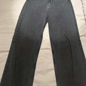 Svarta loose fit jeans - Säljer ett par svarta loose fit jeans med hög midja. De har en rak passform och klassisk design med fem fickor. Perfekta för en avslappnad stil.