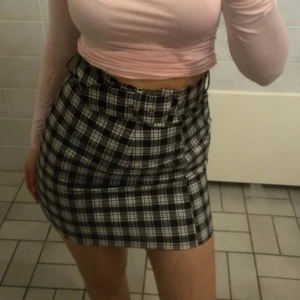 Svartvit rutig kjol från Divided - Snygg svartvit rutig kortkjol från Hm. Perfekt för att ge en stilren touch till din outfit. Kjolen har en klassisk passform och är lätt att matcha med olika toppar.