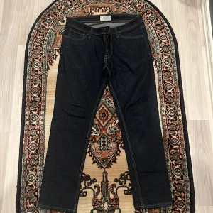 Svarta jeansbyxor från Nudie Jeans - Snygga svarta jeansbyxor från Nudie Jeans med klassisk design. De har en normal passform och är tillverkade i slitstarkt denim. Perfekta för en stilren look.