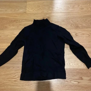 Svart J.Lindberg - Snygg svart J.Lindberg med långärmad design. Perfekt för kyligare dagar och enkel att matcha med olika outfits. Ett stilrent val för garderoben.