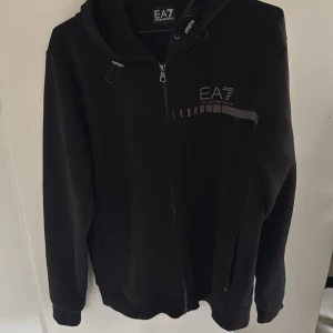 EA7 Emporio Armani tröja - Säljer en svart EA7 tröja, skick 10/10, pris 900 kr, kan tänka mig gå ner vid snabb affär, hör av dig vid frågor!