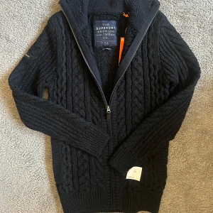 Stickad tröja (HELT NY) - Säljer denna helt nya skitfeta tröjan från superdry i storlek XS. Den passar dig som är mellan 170-180. Den är mörkblå och svart och har ett coolt stickat mönster. Tycker 399 är ett bra pris då den är helt ny. Vet ej nypris då jag fick den men skulle gissa att den kostar minst 700 kr ny. Hör av er vid frågor! Svarar så snabbt jag kan!