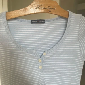 En söt t-shirt från Brandy Melville - Säljer en söt ljusblå randig topp från Brandy Melville. Använd en gång och ser som gott ny ut. Den är one size men skulle säga att den är runt xxs/xs och skulle kunna passa S efter den är stretchig!🩷🩷