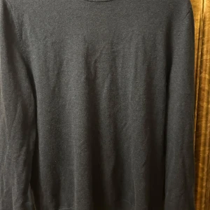 Mörkblå tröja från Filippa K - Tja! Säljer en 50/50 bomull och ull tröja från Filippa K. Tröjan har en klassisk design som passar det flesta. Tröjan har lite defekter som man ser och därav priset!