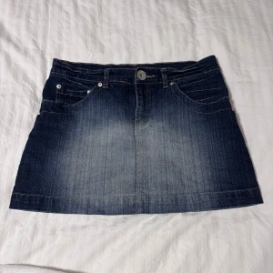 Jeanskjol  - Snygg jeanskjol i mörkblå denim med klassisk femficksdesign och knappstängning fram. Perfekt för en avslappnad stil. Märket är M.A.P.P storleken är oklart men jag har den lågat och då fattar den nog som vanligt hos har storlek 36/38