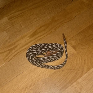 Flätat bälte - Snyggt flätat bälte i svart och vita färg med ett stilrent spänn. Skick 10/10 