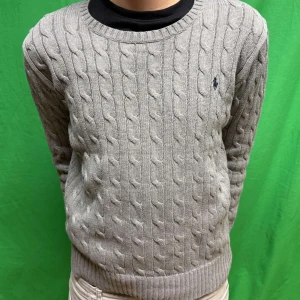 Grå stickad tröja från Ralph Lauren - Säljer en stilren grå stickad tröja från Ralph Lauren med kabelstickat mönster. Tröjan är i storlek L för kids alltså väldigt liten. Skulle säga att den passar någon som är ca 160 cm. Pris kan absolut diskuteras vid snabb affär.😄
