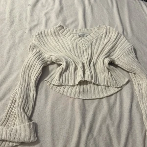 Vit ribbad stickad tröja från Chiquelle - Säljer en snygg vit stickad tröja från Chiquelle. Den är croppad med en v-ringad hals och långa ärmar. Perfekt för en stilren look. Passar bra till både jeans och kjol. 🖤