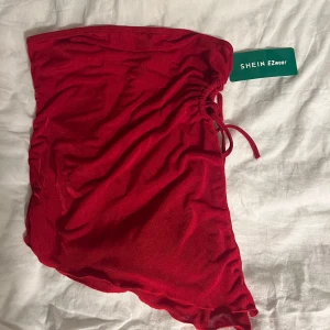 Röd sommartopp  - Jättefin helt ny röd ”tubtopp” till sommaren. Har ej använt den då ja inte känner mig helt bekväm i den. Den är lite genomskinlig.