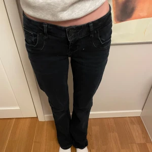 Svarta jeansbyxor ltb - Snygga svarta jeansbyxor med låg midja och en klassisk femficksdesign. Byxorna har en straight passform och är perfekta för en avslappnad stil. De har en knapp- och dragkedjestängning framtill.