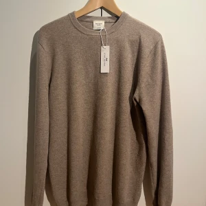 Beige kashmirtröja från John Henric - Säljer en stilren beige kashmirtröja från John Henric. Tröjan har en klassisk rund hals och långa ärmar, perfekt för en elegant och bekväm look. Den är tillverkad i mjuk kashmir som ger en lyxig känsla.