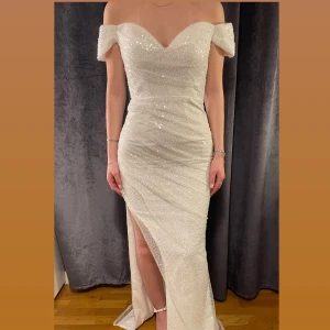 Vit glittrig långklänning från Dressroom Linné - Vit jättefin balklänning från Dressroom. Säljer på grund av att jag köpte för stor storlek då det endast fanns en kvar, annars är den helt perfekt!  Har alltså aldrig använts!! (Det går inte att lämna tillbaka till butiken och därav säljer jag den här)  En helt ny dressroom klänning men för ett billigare pris☺️  Nypris: 4500 kr