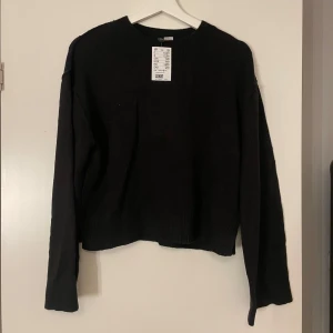 Svart stickad tröja från H&M - Säljer en svart stickad tröja från H&M. Tröjan har en croppad design med långa ärmar och rund hals. Sömmarna är designade att se lite större ut. Helt oanvänd och prislappen sitter fortfarande kvar!💕