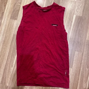 Röd ärmlös topp från Conway - En röd ärmlös tröja från Donnay i storlek S. Perfekt för sommardagar eller träning. Oanvänd!!