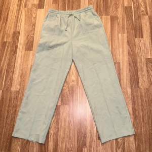 Beige byxor med resårmidja - Gröna byxor som påminner om kostymbyxor. Helt nya från Miss Selfridge i storlek 40