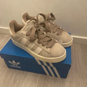 Adidas Campus 00s ”wonder biege” - Säljer ett par Adidas Campus i färgen ”wonder biege” som är köpta från Merchsweden. Storleken är 41 1/3 men passar mindre. Skorna är endast testade och kommer med låda och kvitto😊  Tveka inte på att ställa några frågor😀