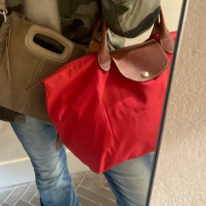 Longchamp väska  - Säljer min röda longchamp väska i mellan modellen! Använd men fortfarande i fint skick! 