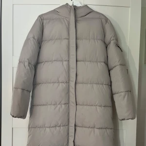 Vinterjacka NA-KD  - Lång beige vinterjacka från NA-KD. Nästan helt oanvänd, säljer för att den är lite stor.