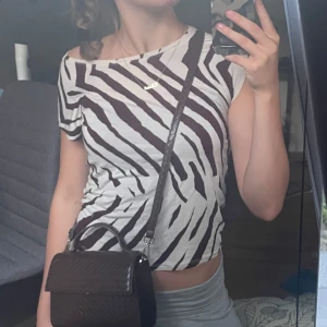 Zebramönstrad topp från Lindex - Säljer en supercool zebramönstrad topp från Lindex i storlek XS men passar som S. Den är i en beige och brun färgkombination. Perfekt för en avslappnad dag eller en utekväll. Toppen är kortärmad.🫶🏻🫶🏻