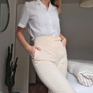 Ljusgula byxor - Ljusgula byxor från Mango, XS. Något kortare än "vanliga" byxor. I fint skick förutom en liten fläck i nedre delen av ena benet (se sista bilden). Går eventuellt att få bort med fläckborttagning (har ej testat) men annars inget jag stört mig på.