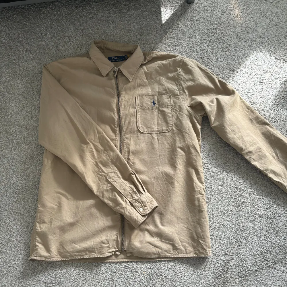 Overshirt från Ralph Lauren i bra skick förutom att det är ett litet hål på ryggen. Storlek M Pris 499. Jackor.