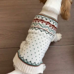 Vit stickad hundtröja med mönster - Söt vit stickad hundtröja med traditionellt mönster i grönt och rött. Perfekt för att hålla din fyrbenta vän varm under kyliga dagar. Tröjan har ribbade kanter för en bekväm passform. Helt oanvänd då den var för liten för min hund 