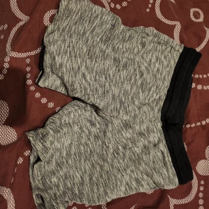 Gråmelerade shorts med svart resår - Snygga gråmelerade shorts med svart resår i midjan. Perfekta för en avslappnad stil. De är tillverkade i ett mjukt och bekvämt material.