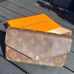 Pochette Felicie från Louis Vuitton i Monogram - Snygg brun väska från Louis Vuitton med det klassiska monogrammönstret i guld. Kommer med originalförpackning. Knappt använt och kostar 14.400kr nypris.