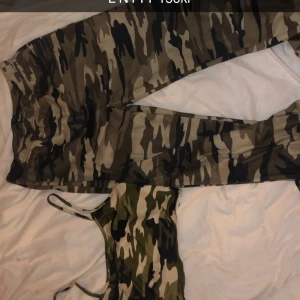 Camouflage cargopants med matchande tubtopp - Säljer ett par coola camouflage cargopants med matchande tubtopp. Byxorna har en loose passform och är perfekta för en avslappnad stil. Tubtoppen kompletterar looken och ger en trendig touch.