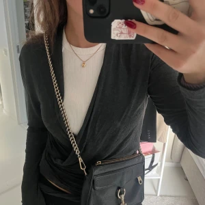 Rebecca Minkoff väska - Rebecca Minkoff väska i svart med gulddetaljer. I använt skick men fortfarande fin! Handtaget på kedjan har gått av, se sista bild. Bandet går att sätta upp och korta ner så den går att bära på flera sätt, bland annat som en clutch.