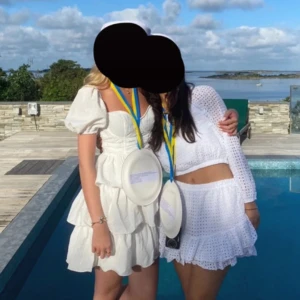 Vit klänning från PrettyLittleThing - Säljer min studentklänning från PrettyLittleThing med puffiga kortärmar och volangdetaljer. Den har två hål som är lagade men det syns ej när man har klänningen på sig. Se bild 3 och 4. 