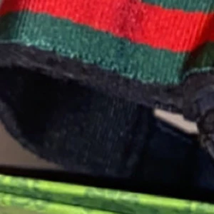 Randigt bälte med gröna och röda ränder - Snyggt bälte med breda gröna och röda ränder. Perfekt för att ge en färgklick till din outfit. Bältet har en klassisk design och passar till många olika stilar.