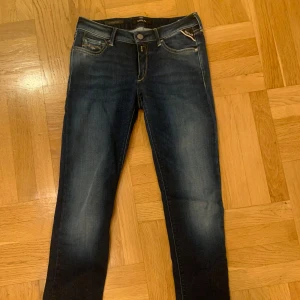  Replay jeans - Snygga mörkblå jeans från Replay med klassisk femficksdesign och knappgylf. Perfekta för en elegant stil. Märkesdetaljer på fickorna och bältesslingor för extra stilpoäng. Skick: 9,5/10