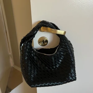 Svart flätad handväska - Snygg svart flätad handväska med dragkedja. 