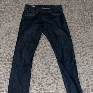 501Mörkblå jeans från Levi's  - Snygga mörkblå jeans från Levi's med klassisk design och fem fickor. Perfekta för en avslappnad stil. De har en normal passform och är tillverkade i slitstarkt denim.