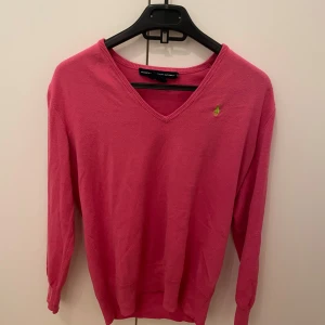 Rosa tröja från Ralph Lauren - Snygg rosa tröja från Ralph Lauren med v-ringning och broderad logga på bröstet. Perfekt för en stilren look.