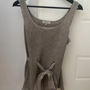Beige superfin topp från K.U.S  - Stilren beige topp från K.U.S Stockholm. Den har knytning i midjan och är ärmlös. Säljs ej längre.