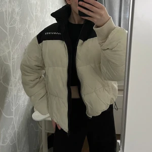 Pufferjacka  - Snygg beige pufferjacka från Missguided med svarta detaljer och dragkedja. Jackan har en hög krage och är perfekt för kyligare dagar. Ingen luva! I väldigt bra skick☺️