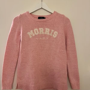 Rosa stickad tröja från Morris Lady - Säljer en snygg rosa stickad tröja från Morris Lady med texten 'Morris Lady' i vitt på bröstet.  Mycket bra skick, stelare än ny. 