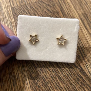 Guldstjärna örhängen med diamanter i - Snygga örhängen i form av stjärnor i guld med glittriga diamanter som detalj. Helt oanvända 