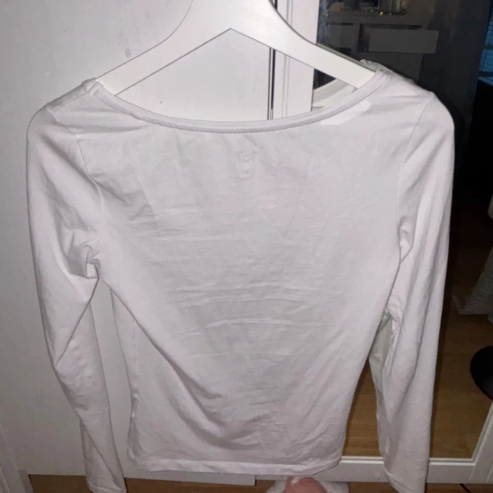 Säljer en stilren vit långärmad topp från 157. Perfekt för lager-på-lager eller som den är. Tillverkad i mjukt bomullsmaterial för en bekväm passform.. Neuletakit & Villapaidat.