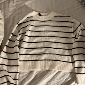 Randig croppad tröja från H&M - Säljer en snygg randig tröja från Divided  (H&M) i svart och vit. Den är gjord i ett mjukt material som känns skönt mot huden.