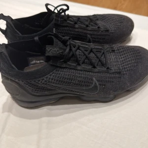 Svarta Nike Vapormax sneakers - Snygga svarta Nike Vapormax sneakers med stickad ovandel och synlig luftdämpning i sulan. Perfekta för både träning och vardag med en modern design och bekväm passform.