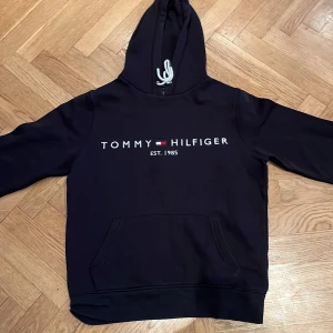 Svart hoodie från Tommy Hilfiger - Säljer nu mi tommy hilfiger hoodie i S. Använd men utan defekter. Har växt ut den och de är därför jag säljer den. Pris kan diskuteras!